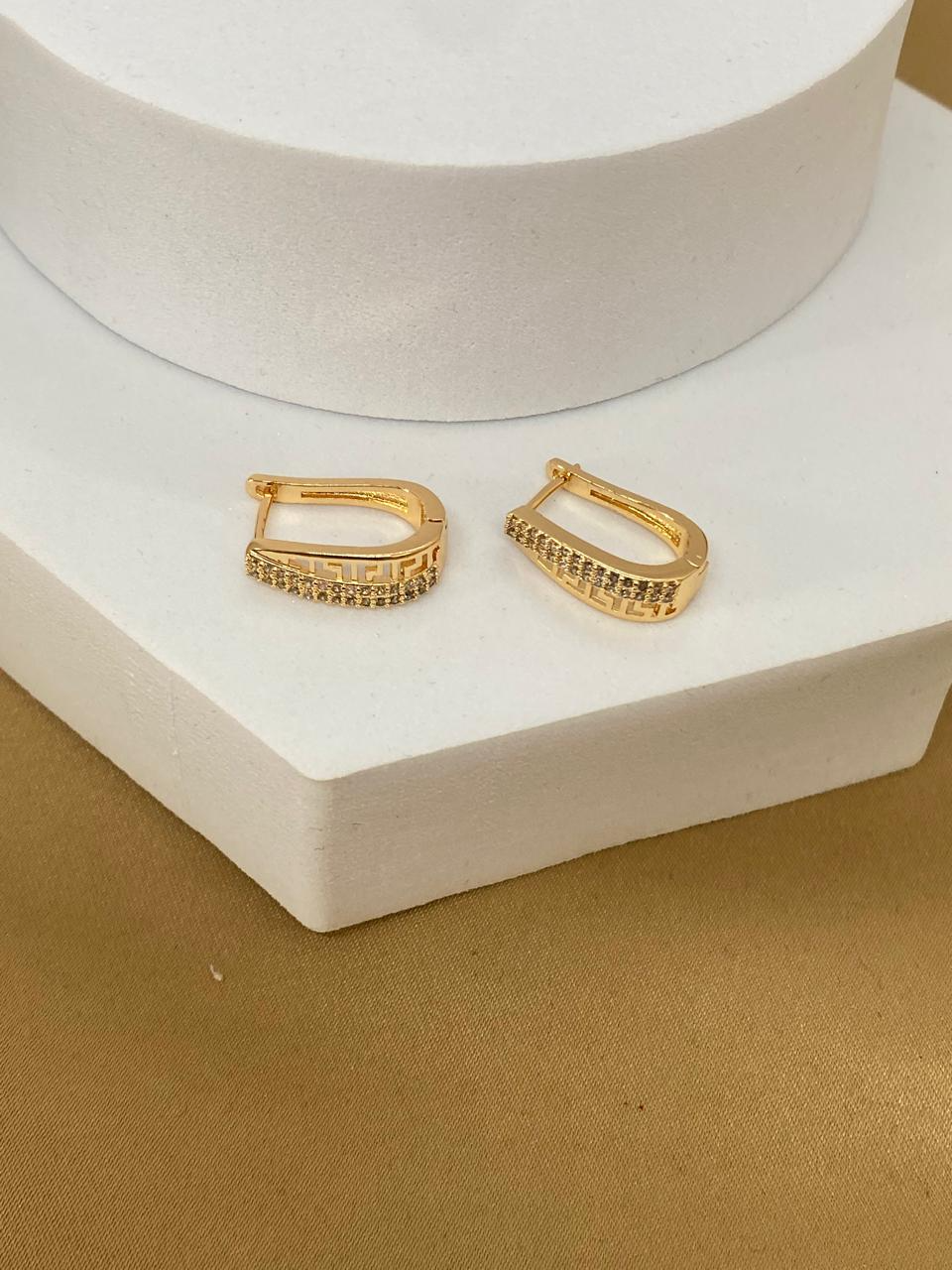A26475 Arete alargado doble fila con brillo y símbolo.  Material: Oro Laminado 18k.