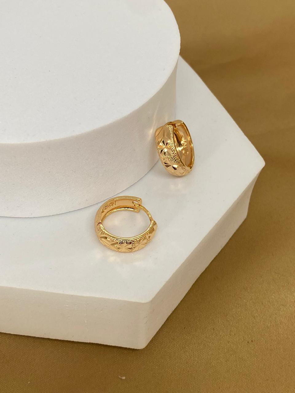 A26474 Arracada con grabado de estrella    Material Oro laminado 18k.